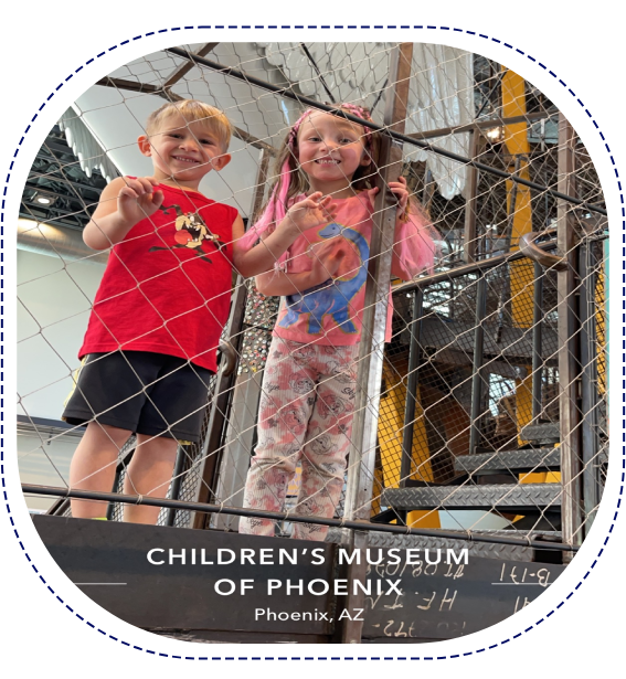 Two children standing in a cage at the museum.