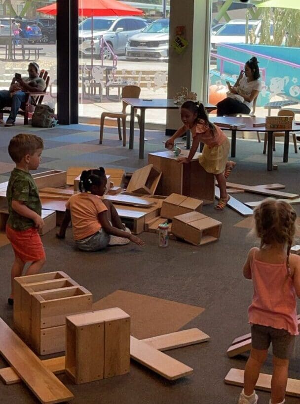 A group of children playing with boxes in an indoor setting.