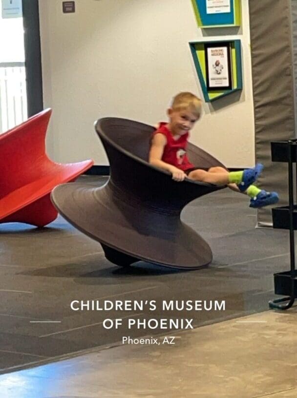 A young boy sitting on top of an object.