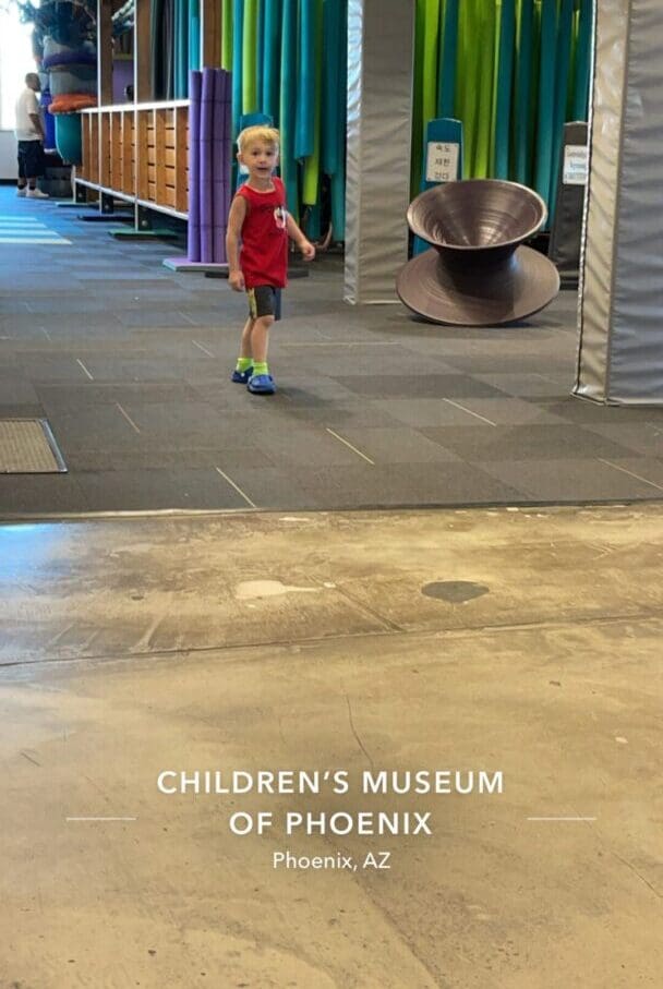 A young boy standing in front of an exhibit.