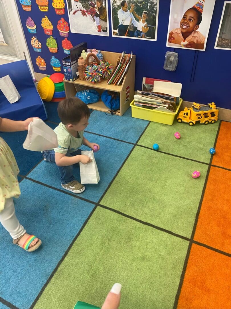 A child is playing with an object on the floor.