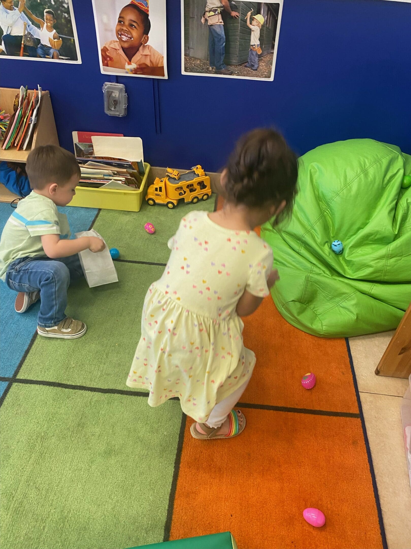 Two children playing with a toy on the floor.