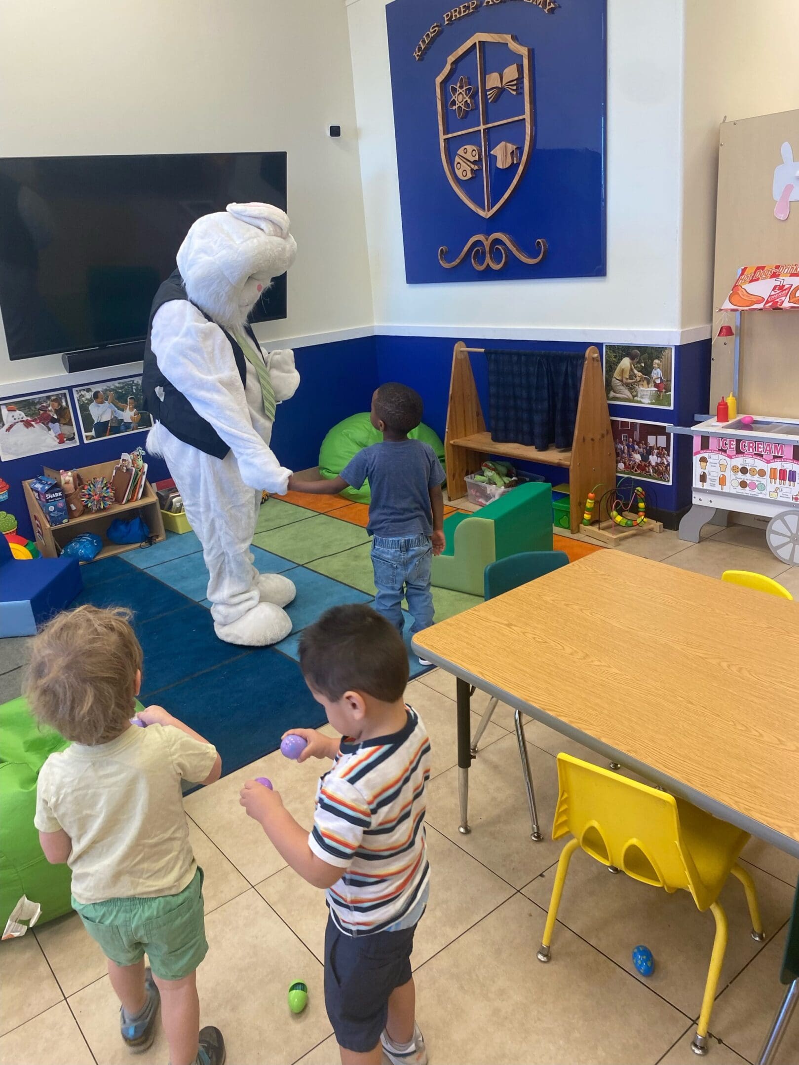 A group of children in the room with an animal.