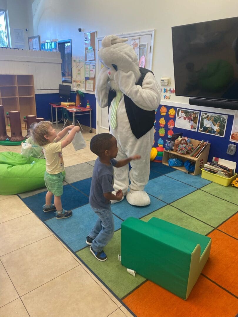 A child is playing with an animal in the room.