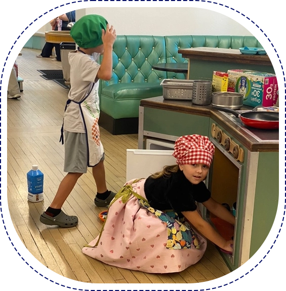 A boy and girl playing in the kitchen.