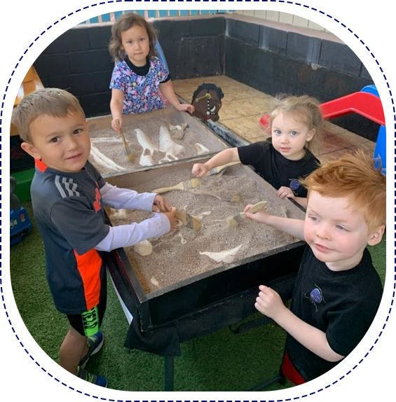 A group of children playing with sand in a sandbox.