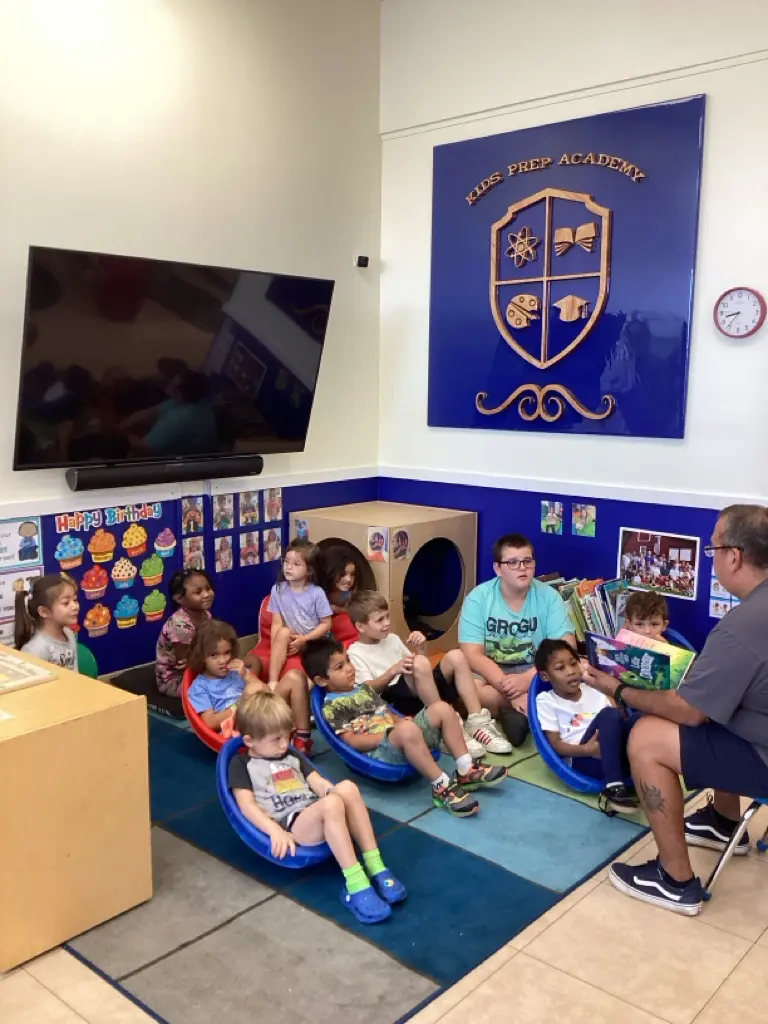 A group of children sitting in front of a television.