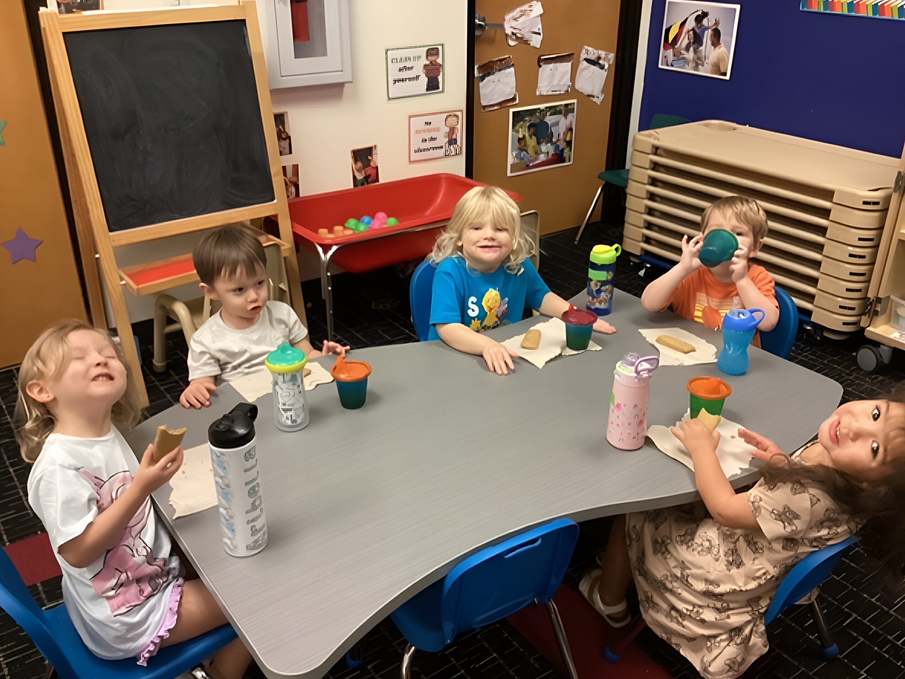 A group of children sitting at a table with drinks.