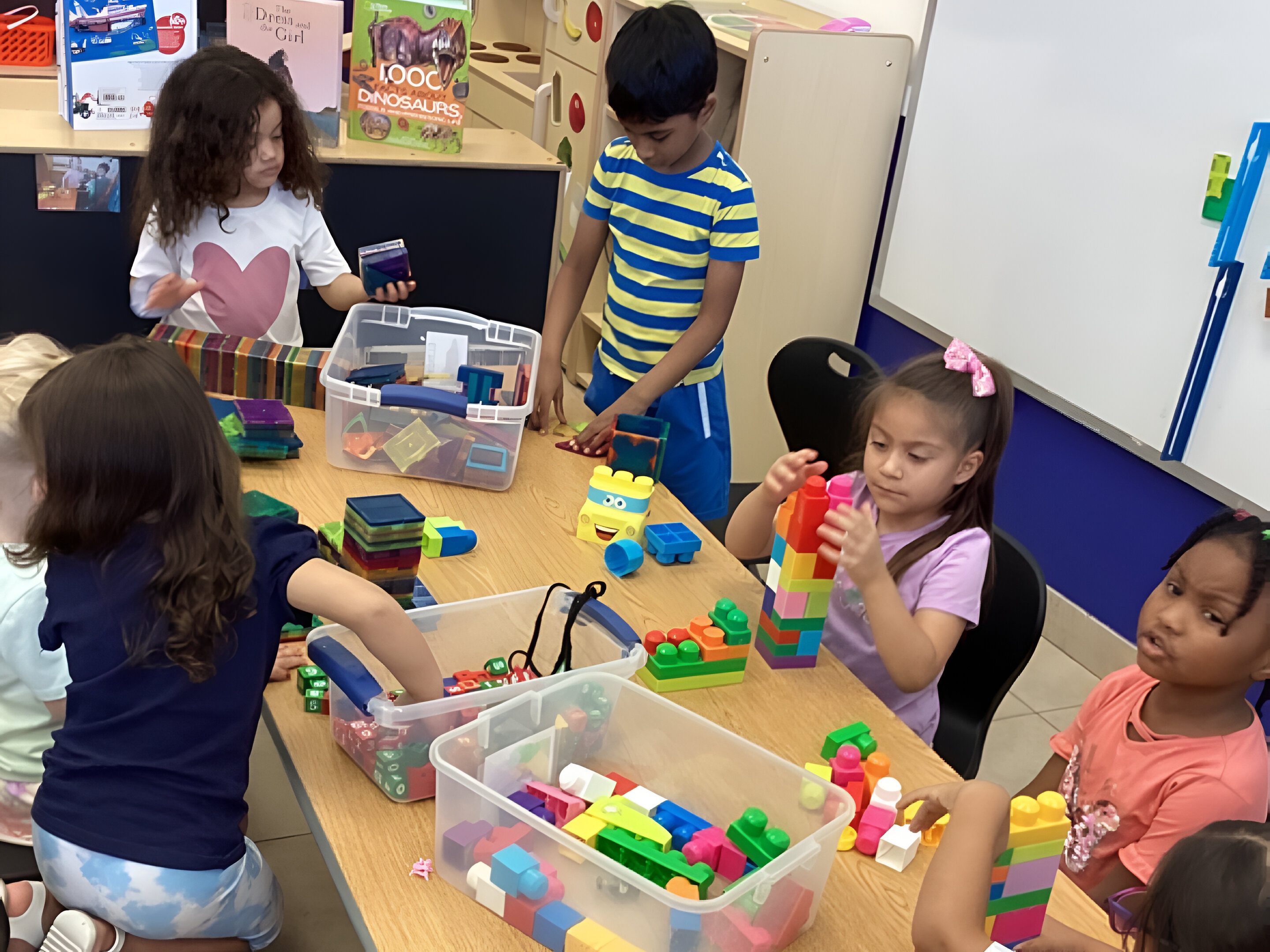 A group of children playing with blocks at the table.