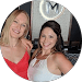 Two women posing for a picture in front of a mirror.